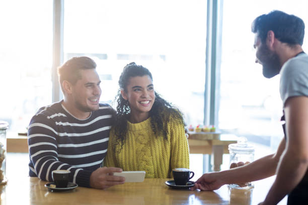 istock Waiter serving a cup of coffee to customer 651757442