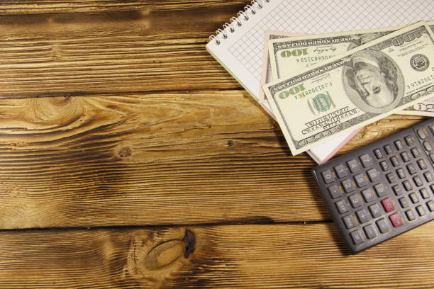 istock Notebook with dollars and calculator on wooden desk 651765160
