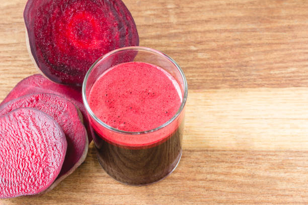 istock Fresh beet juice in glass and sliced beetroot on wooden table. 651768918