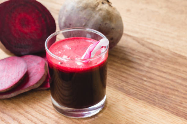 istock Fresh beet juice in glass and sliced beetroot on wooden table. 651768952