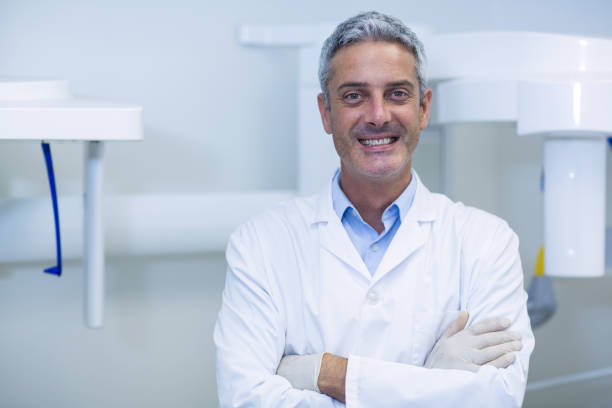 istock Smiling dentist standing in dental clinic 651772608
