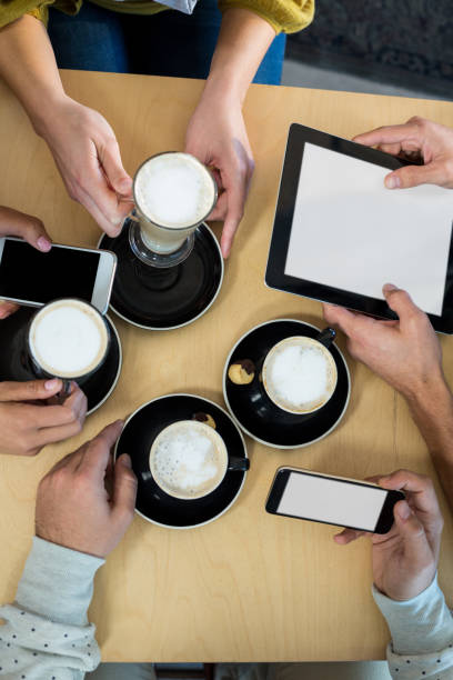 istock Friends using mobile phone and digital tablet while having cup of coffee 651772900