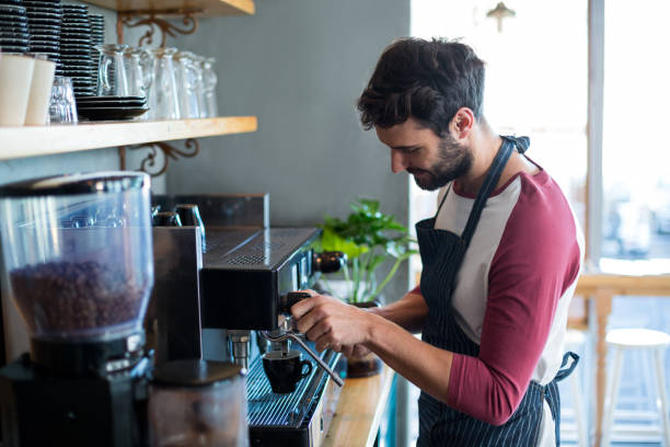 istock Waiter making cup of coffee in cafe 651791594