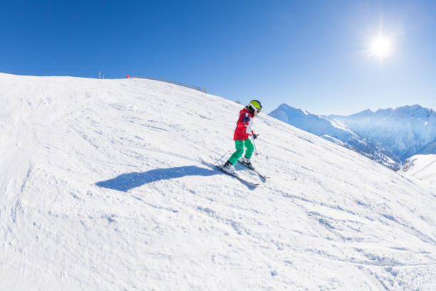 istock Little skier walking down the hill at sunny day 651791804