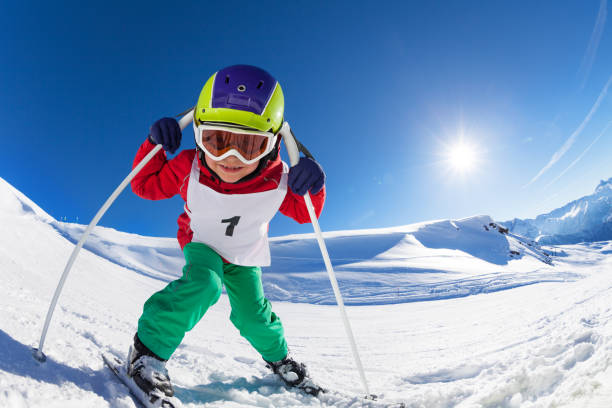 istock Cute little skier posing with poles at sunny day 651792336