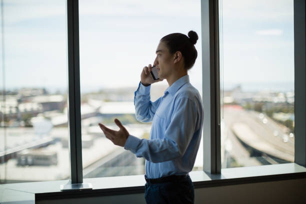 istock Business executive talking on mobile phone in corridor 651795046