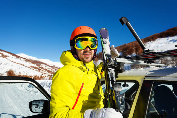 istock Active man unloading skis from car roof rails 651795352