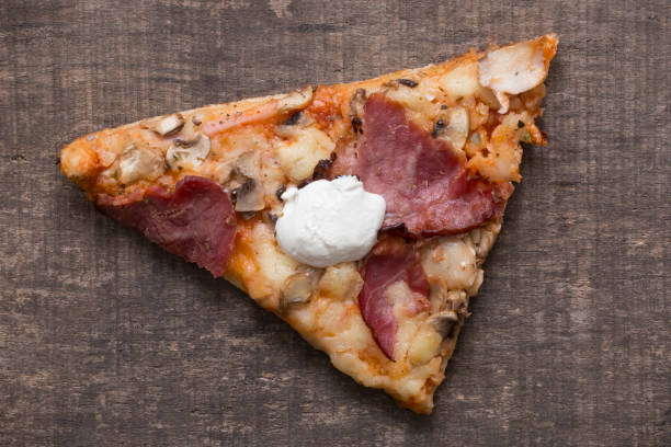 istock Slice of pizza on old wooden table. Directly above view. 651802306