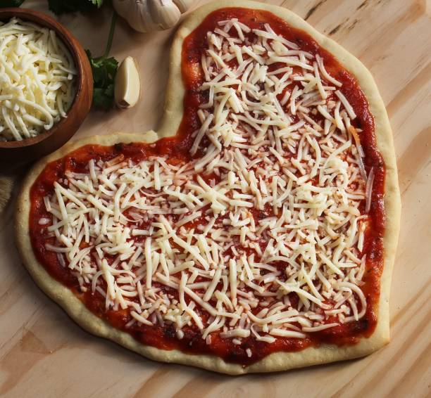 istock Heart shaped pizza ready to bake overhead view 651809306