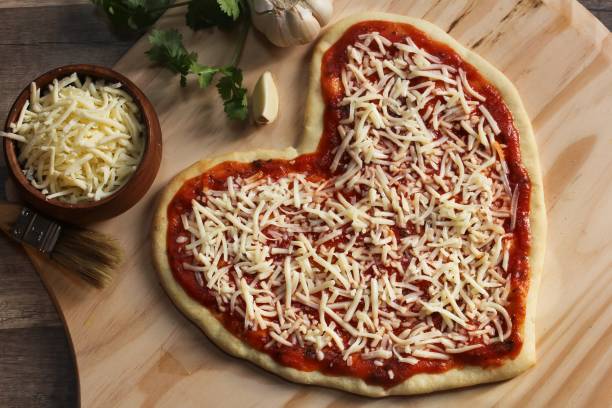 istock Heart shaped pizza ready to bake overhead view 651811344