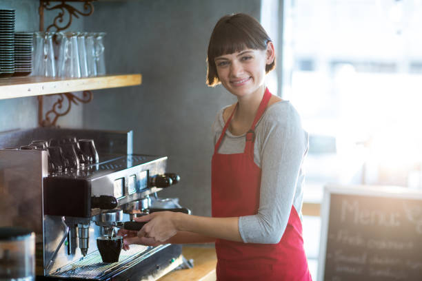 istock Smiling waitress making cup of coffee in cafe 651814122