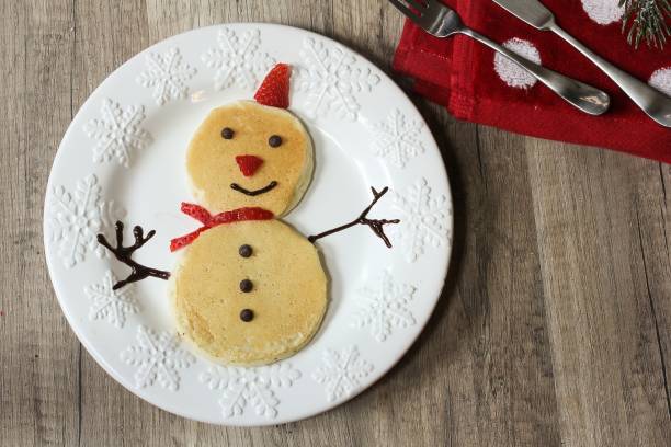 istock Snowman pancakes for Christmas breakfast for kids top down view 651871774