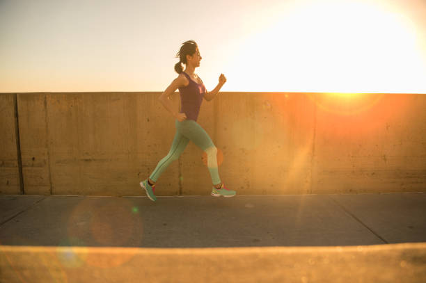 istock Young Women Silhouette Running At Sunset 651883920