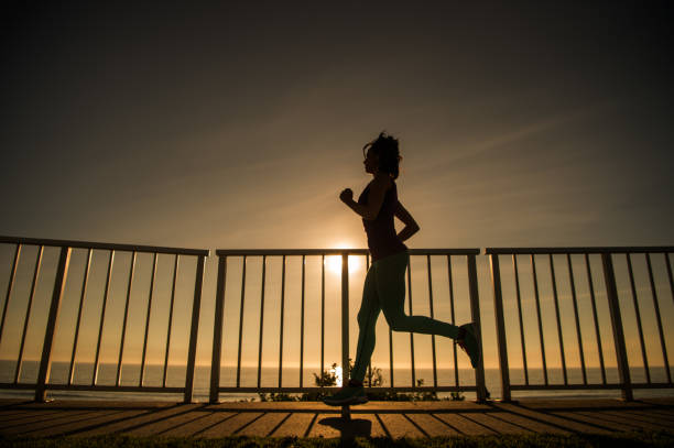 istock Young Women Silhouette Running At Sunset 651889188