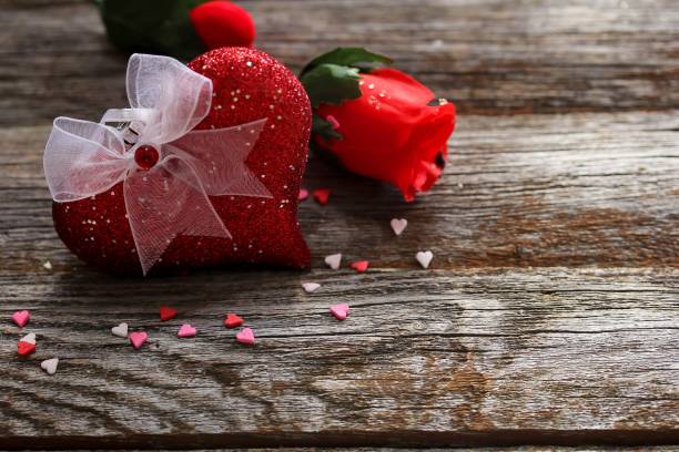 istock Valentine's day background with red heart and rose on rustic wooden background 651893862