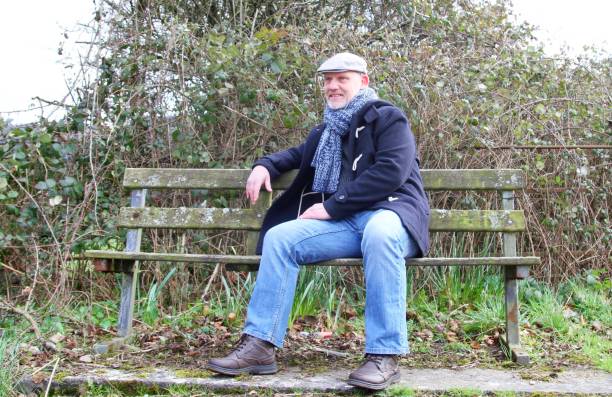 istock mature man wearing winter clothes sitting on bench 651908004