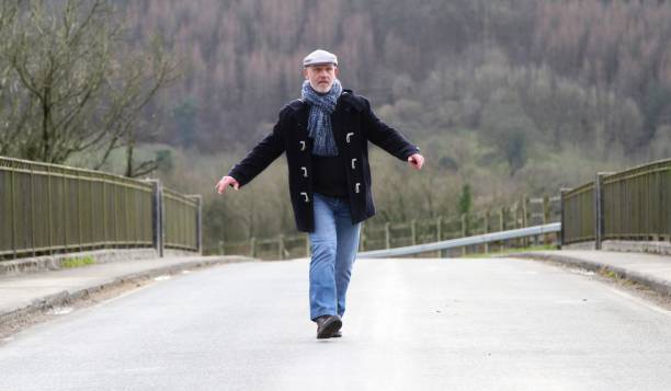 istock Mature man walking on remote country road 651918578