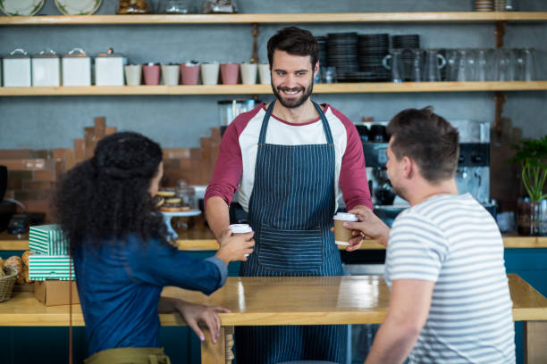 istock Waiter serving a coffee to customer at counter 651926904