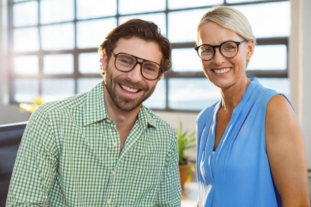 Graphic designer and colleague smiling in office Portrait of graphic designer and colleague smiling in office horn rimmed glasses stock pictures, royalty-free photos & images