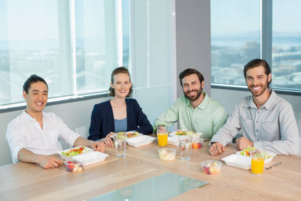 istock Smiling business executives having meal in office 651970336