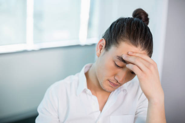 istock Tense business executive sitting with hand on forehead 651970396