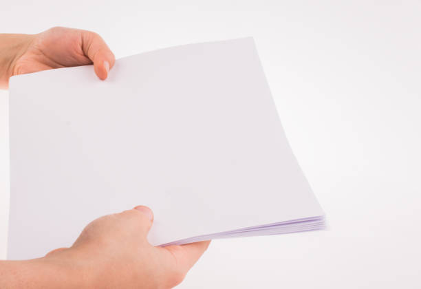 istock Hand holding a white blank sheet of paper 651970436