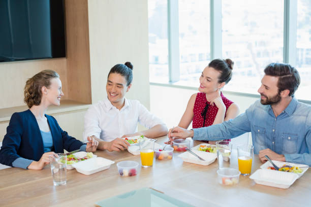istock Smiling business executives having meal in office 651970478