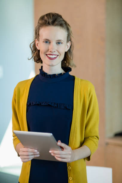 istock Smiling female business executive holding digital tablet in office 652038146