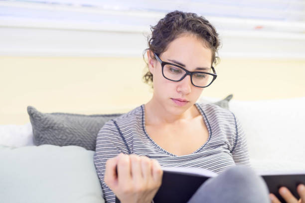 istock Attractive young Hispanic woman on bed reading journal 652093584