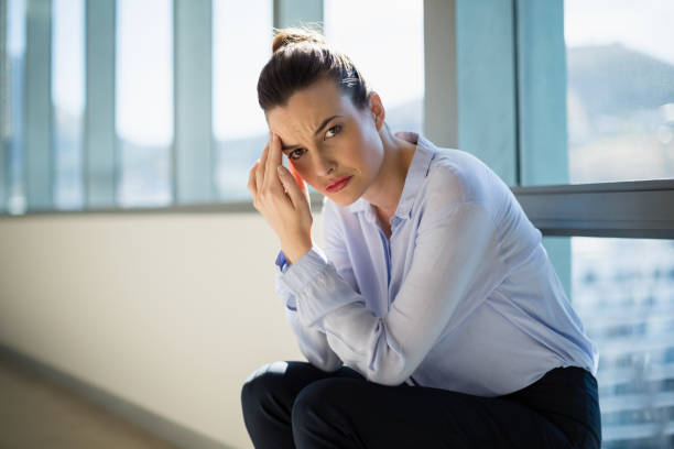 istock Tense female business executive sitting with hand on forehead 652118448