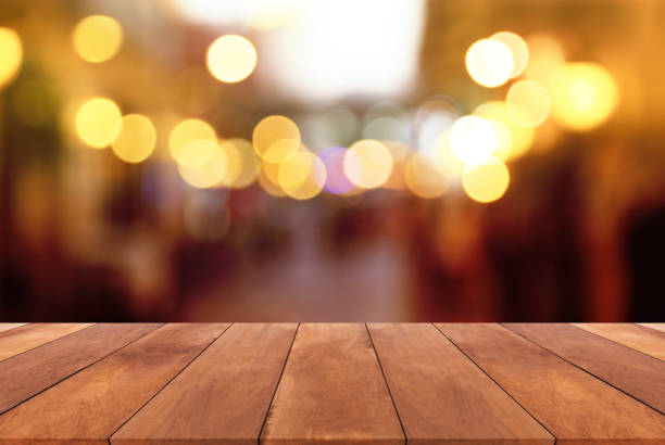 istock Abstract blurred image and bokeh lights in the night with wood table 652118686