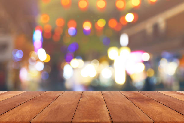 istock Abstract blurred image and bokeh lights in the night with wood table 652118714