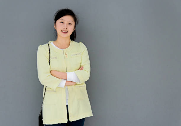 istock Young woman smiling against gray wall 652124956