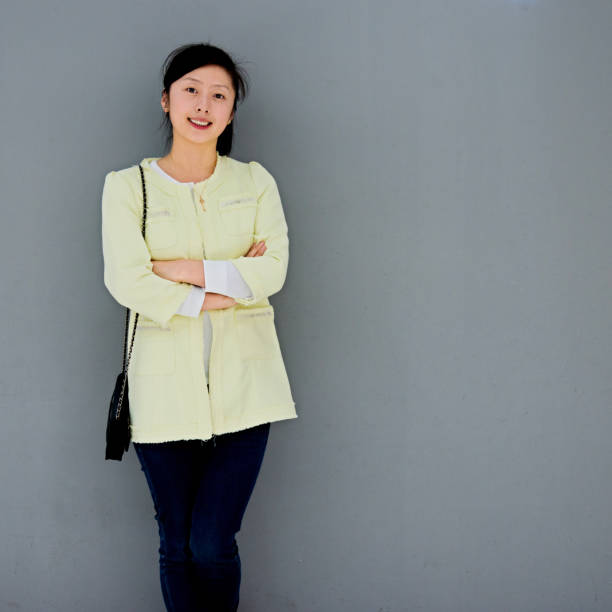 istock Young woman smiling against gray wall 652124958