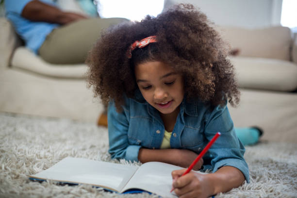 istock Girl doing homework while lying on the floor 652124960