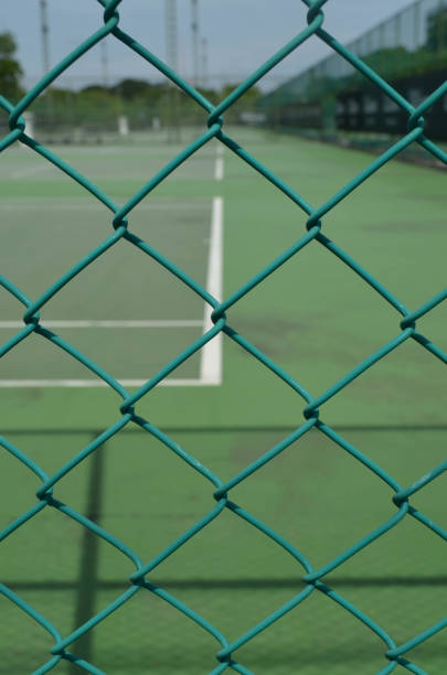 istock Security wire mesh fence with blurred tennis court background 652134560