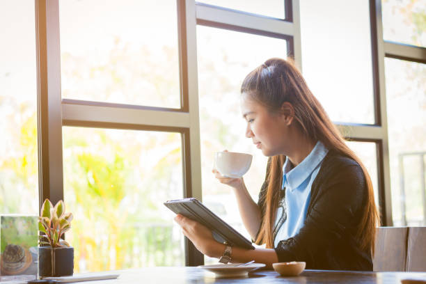 istock Young woman is drinking coffee with using tablet in coffee shop 652136890