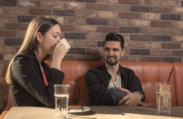 istock young woman drinking cafe, man looking at her 652140944