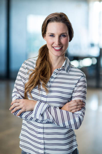 istock Woman standing with arms crossed in office 652159002