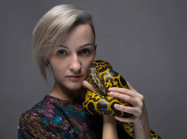 istock Blond woman holding anaconda 652159232