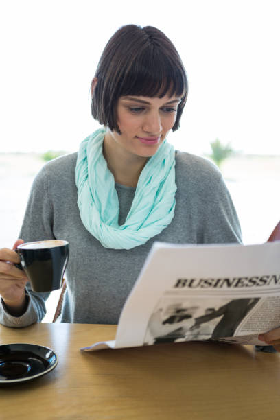 mujer leyendo el periódico y tomando café - hotel newspaper coffee reading fotografías e imágenes de stock