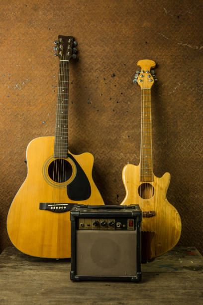 istock Acoustic guitar and amplifier resting against old steel background 652173416