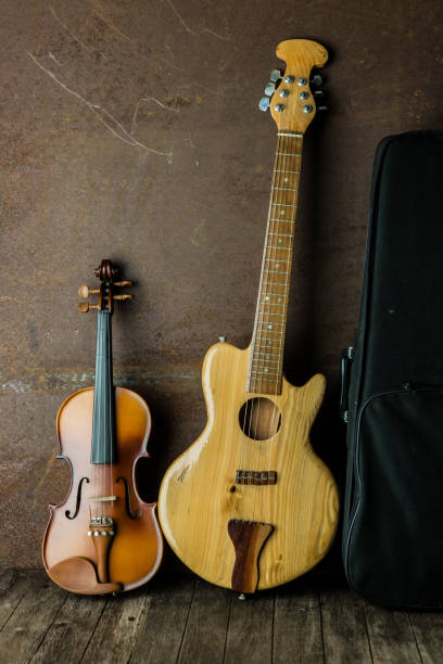 istock acoustic guitar, violin on wooden background 652173602