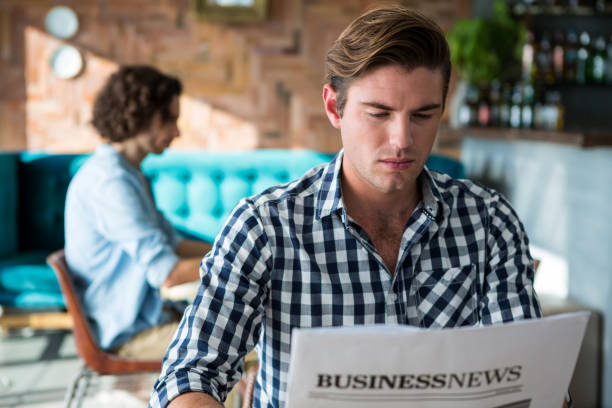 hombre leyendo un periódico de negocios - hotel newspaper coffee reading fotografías e imágenes de stock