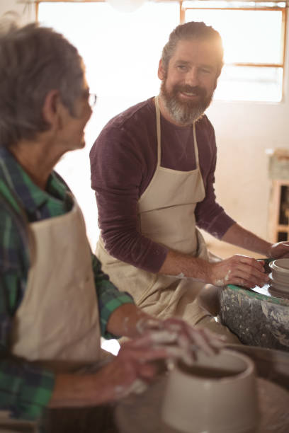 istock Male potter interacting with female potter 652180326