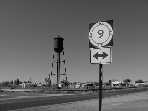 Road scene of Columbus New Mexico with highway 9 sign, and a water tower.  Vintage looking and deserted.