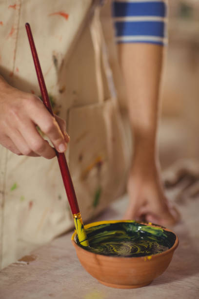 istock Mid section of potter mixing watercolor in bowl 652191124