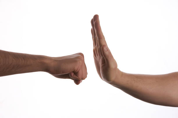 istock One hand preventing punch attack of another hand 652191762