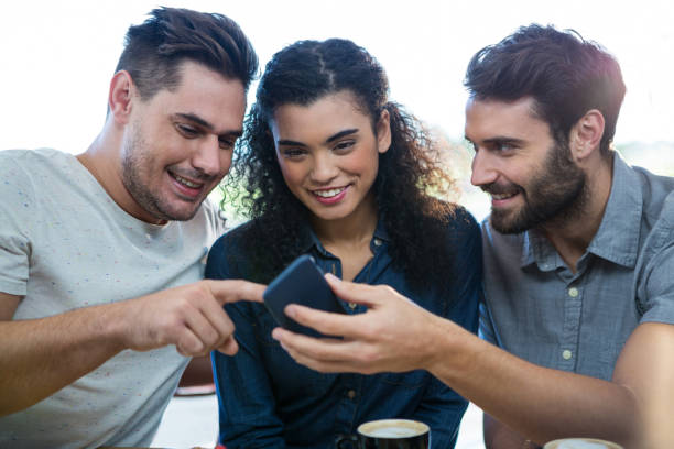 istock Three friends using mobile phone in the coffee shop 652195212