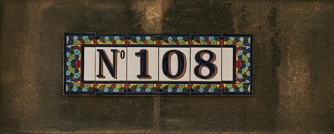 House number one hundred and eight sign on stone wall